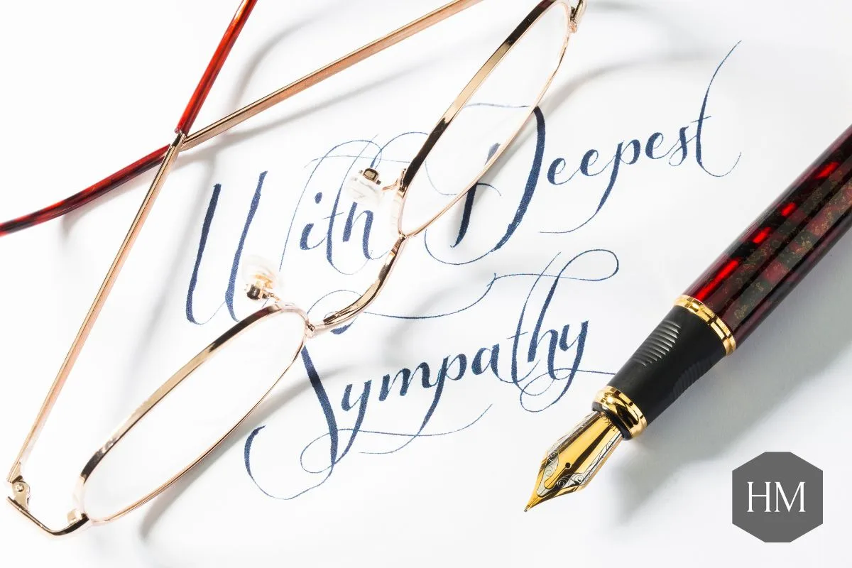 Card with "with deepest sympathy" written on with a fountain pen and glasses